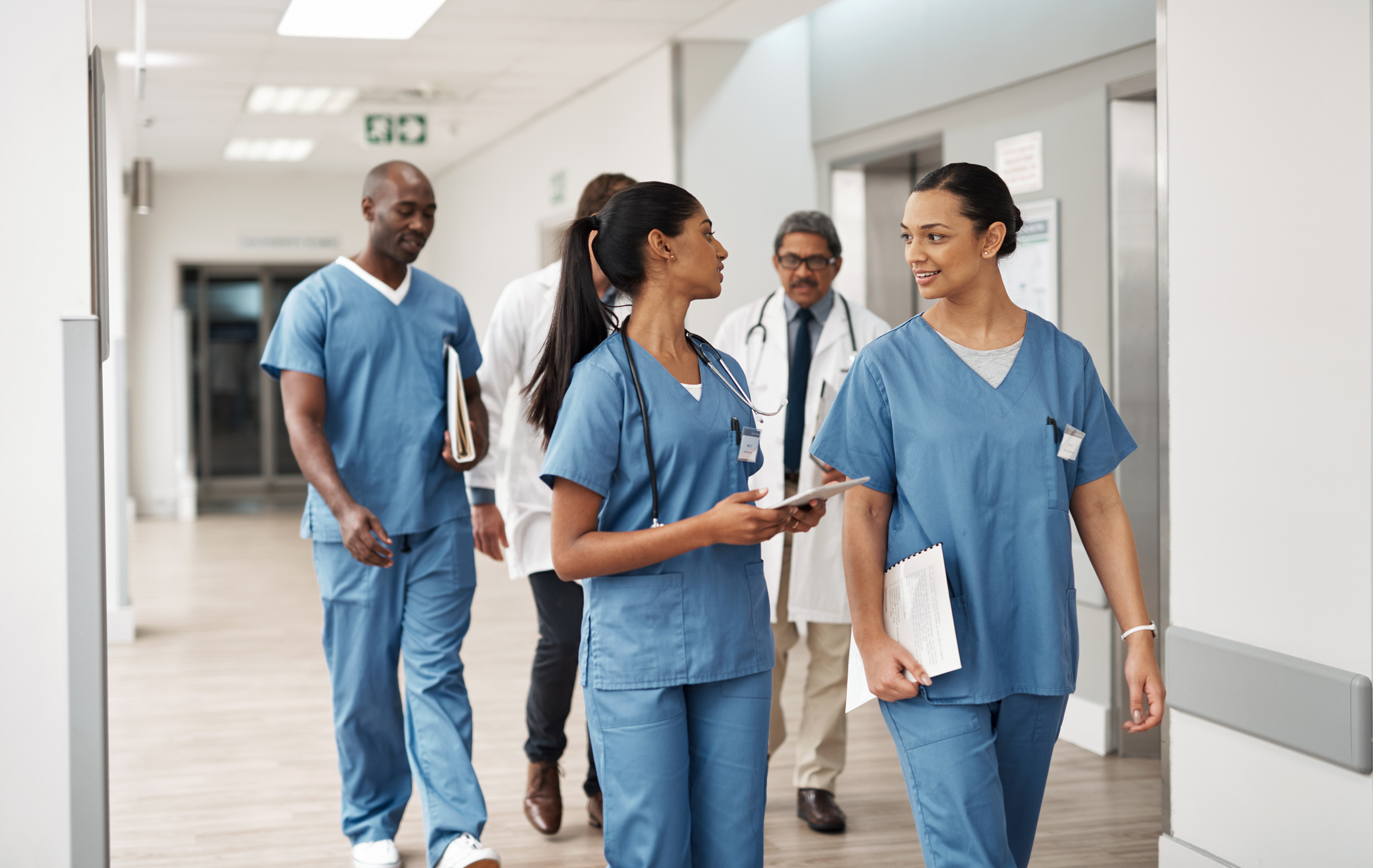 Nurses walking together down a hallway
